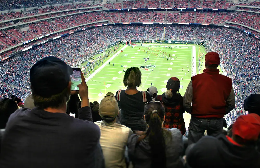 Fans watching a football half-time show at an American football game.